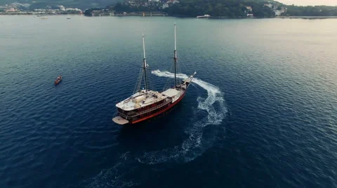 The camera rotates around a sailing ship in the sea. Aerial made with drone N. Stock Footage 63386337