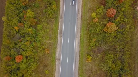 Camera rotates over highway with passing cars background autumn colored forest Stock Footage 98855178