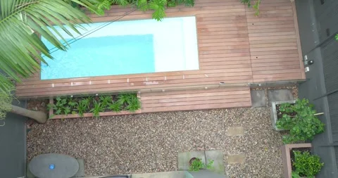 Camera is rotating clockwise and panning over plunge pool with deck revealing Stock Footage 335070275