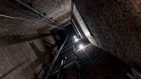 Camera rotating in elevator well in red brick building. Video stock 146395595