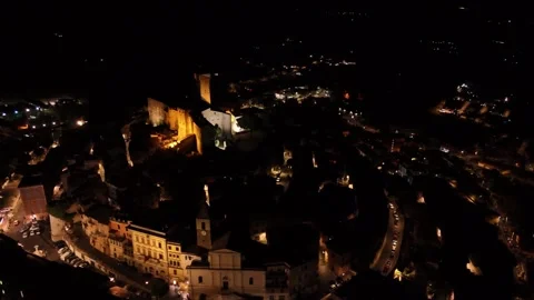 Camera rotating over small illuminated city at night Stock Footage 282659268