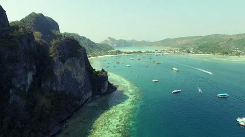 The camera runs along the mountains overlooking the sea with boats. Aerial N. Stock Footage 63657162