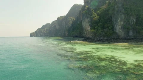 The camera runs along the mountains overlooking the sea on the water surface. N. Stock Footage 63747602
