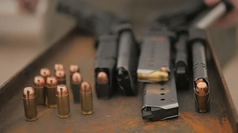 Camera Scans a Table Top Covered with Guns and Ammo Stock Footage 60690384