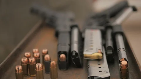 Camera Scans a Table Top Covered with Guns and Ammo 2 Stock Footage 60690427