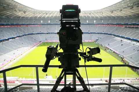 A camera is set up on a tripod in a stadium Stock Photos