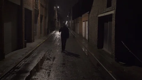 Camera shaking going backward while scary men waving in dark alley Stock Footage 124279463