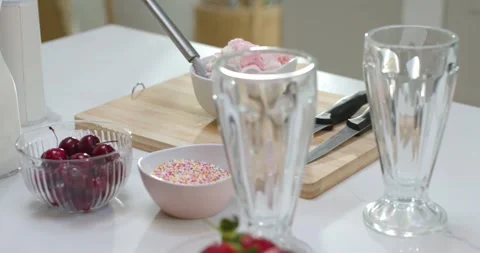 Camera is shifting focus to reveal pink ice cream bowl with toppings on cutting Stock Footage 344404986