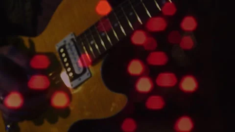Camera shifting, guitarist's hands plucking strings for recording, red hex bokeh Stock Footage 330603067