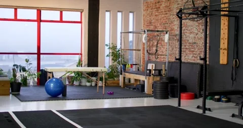 Camera is shifting rightward to reveal rig and weights beside massage table and 스톡 동영상 342032747