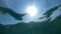 The camera shooting under a water with a bright sun background HD Footage