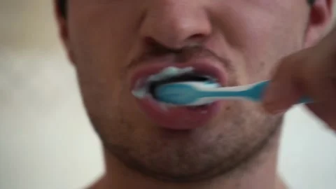 Camera shoots a man brushing his teeth close-up Video stock 158684484