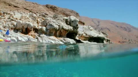 A camera shot in turquoise water half over and half under water Stock Footage 10856859