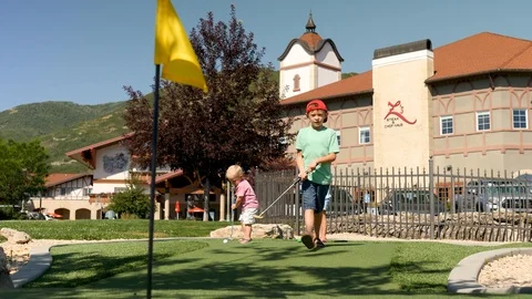 Camera shows yellow golf flag and 2 brothers at background Stock Footage 120031686