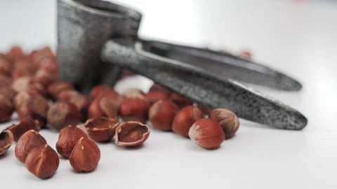 Camera slide movement of hazelnuts and hazelnut cracking tool white background Stock-Footage 130970908