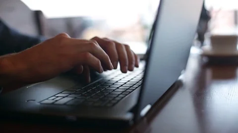 Camera slides around freelancer's hands typing on laptop keyboard in cafe Stock-Footage 84753886