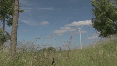 Camera Slides Down to White Electric Windmill with Cinematic Grass Stock Footage 325263127