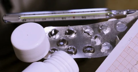 Camera slides from empty tablet package to electrocardiogram Stock Footage 118908969