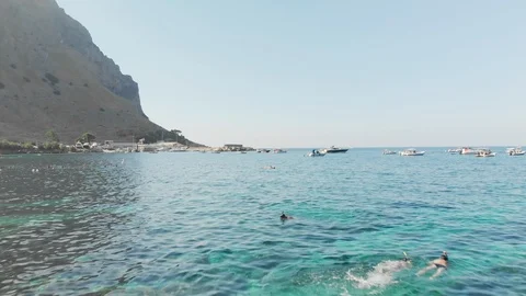 Camera slides over unrecognized people snorkeling in clear water. Seascape, many Video stock 116347888