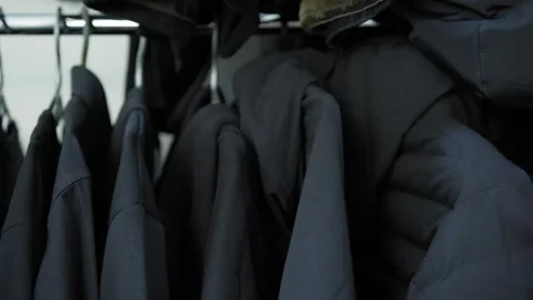 Camera slides past close-up wardrobe with clothing on hangers: sweaters, hoodies Stock-Footage 277076845