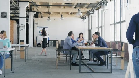 The camera slides through the office. The business team at the big table holds a Stock Footage 111657914