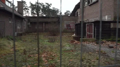 Camera sliding right showing abandoned property behind fence Stock Footage 292924533