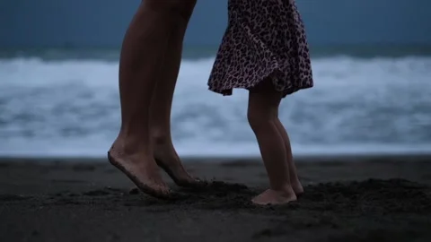 The camera in slow motion shoots two pairs of legs, women's and children's. They Stock Footage 220106419