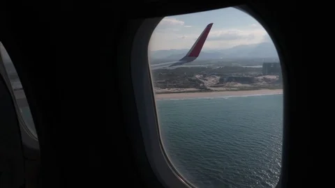 The camera slowly approaches the plane window showing a view of the clouds. 스톡 동영상 117443152