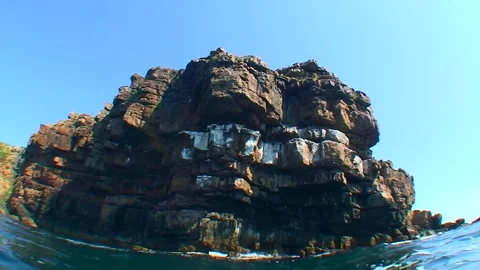 The camera slowly dives under the water next to the rocky coast of the Snake Video stock 258889838