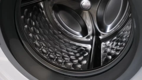 The camera slowly moves along the open washing machine and shows its interior 動画素材 150227126