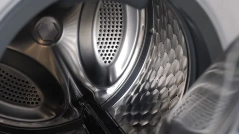 The camera slowly moves along the open washing machine and shows its interior 動画素材 150703647