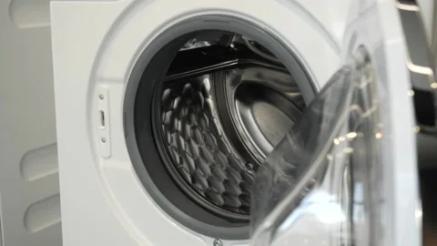 The camera slowly moves along the open washing machine and shows its interior Stock Footage 151381279