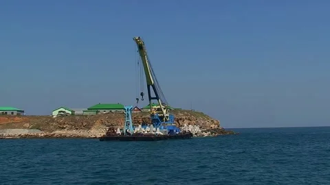 The camera slowly moves along the shore of Snake Island, next to which there is Video stock 242164083