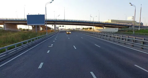 The camera slowly moves back along the road, the golden car comes closer. Stock Footage 61559690