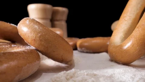 The camera slowly moves through the bagels that lie on the flour. macro plan Видео 144907187