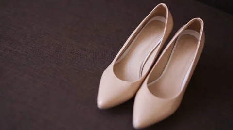 Camera slowly is moving to shoot a pair of classical beige woman's shoes.A Stock Footage 65951691