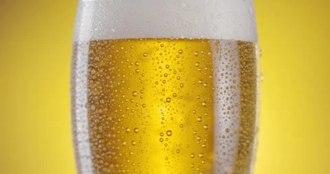 Camera slowly rises up along a beer glass with light beer. 動画素材 251877279