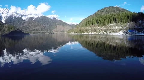 The camera slowly rises over the snow-covered mountain lake Video stock 69036130