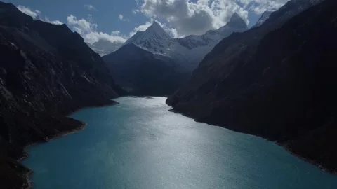 Camera slowly rising up while looking over Laguna Paron to the snow covered  Video stock 252392648