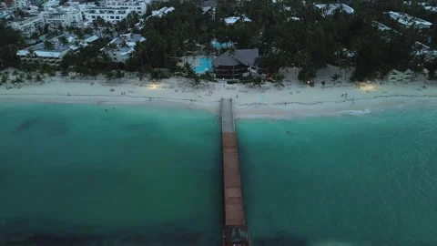 Camera smoothly ascends to capture perspective of pier, tourist beach and hotel Video stock 274166665