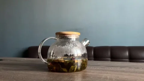 The camera smoothly zooms in on the teapot, inside which tea is being brewed Stock Footage 304160939