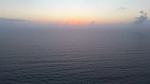 The camera soars through clouds over the sea at sunrise, with golden mornin.. Stock Footage 287555207