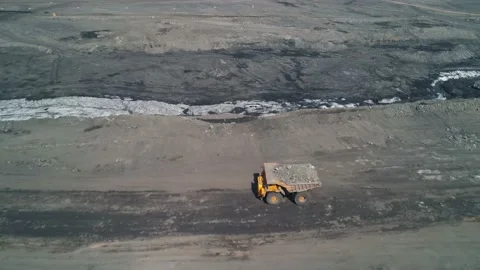 Camera span over big truck loaded with coal and driving along industrial road Stock Footage 203918235