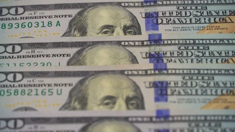 The camera spans from above over evenly placed bills. 100 dollars Stock Footage 123151557