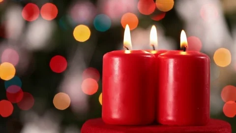 Camera spinning and focusing on three christmas candles Видео 81133979