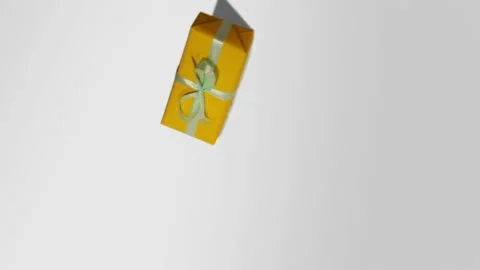 Camera spinning. Yellow gift with a green ribbon on a white background. New Year Stock Footage 142138651