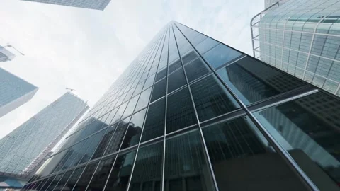 The camera spins around a skyscraper with mirrored windows in the heart of the 库存影片 246653229