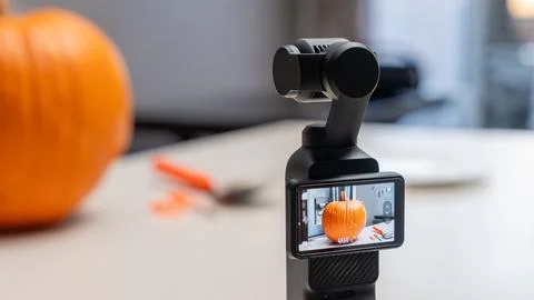 Camera stabilizer capturing a close-up of a pumpkin on a table, with carving Stock Photos