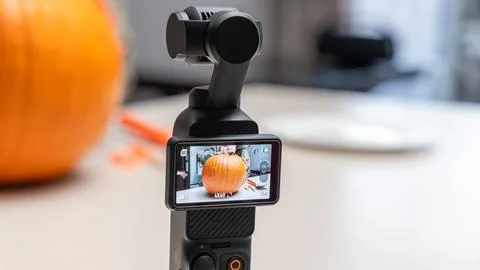 Camera stabilizer capturing a close-up of a pumpkin on a table, with carving Photos