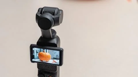 Camera stabilizer with smartphone display showing a pumpkin being cut for Foto stock